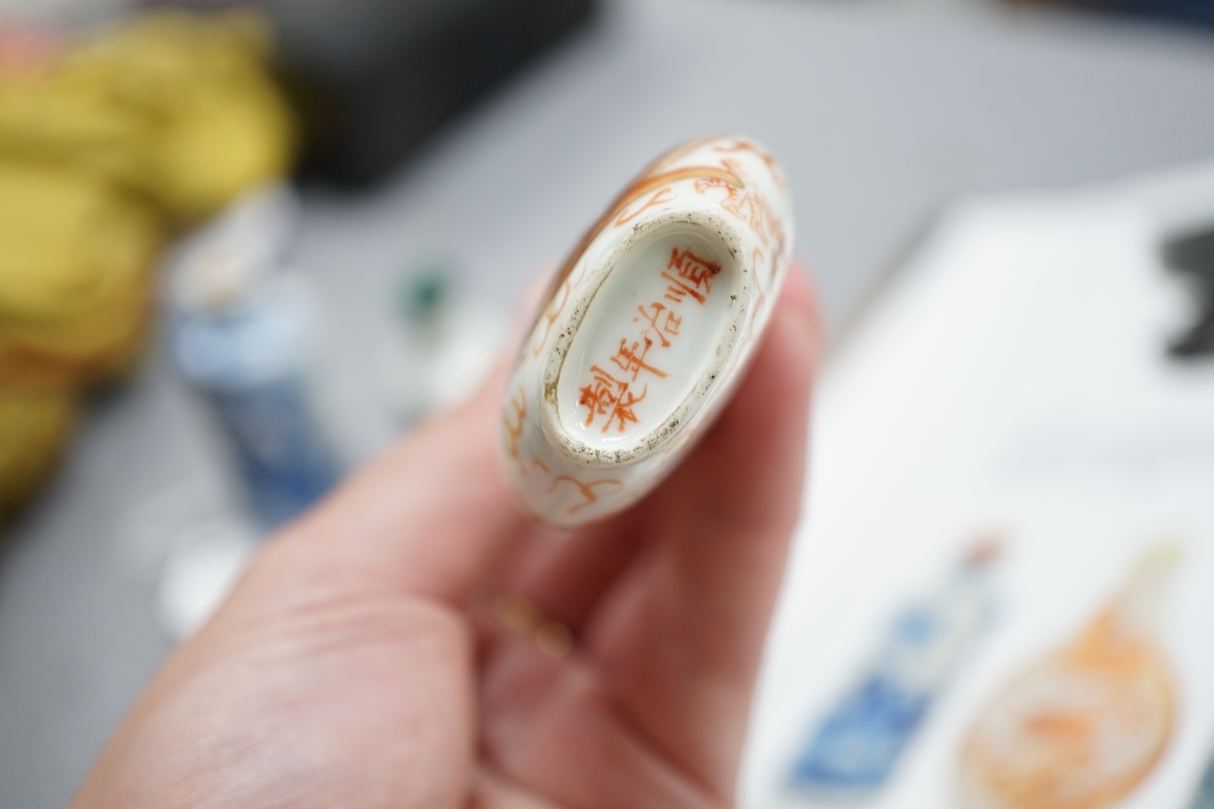 A Chinese iron red enamelled ‘dragon’ snuff bottle, Tongzhi mark and of the period (1862-74), together with two Chinese blue and white cylindrical snuff bottles, 19th century